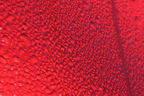 Water beading on a shiny red engineered coating